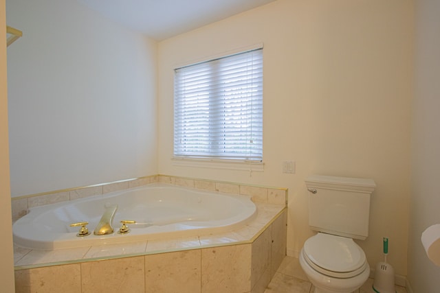 bathroom with tile patterned flooring, toilet, and tiled tub