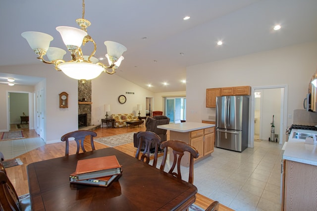 dining space featuring a fireplace, lofted ceiling, and a notable chandelier