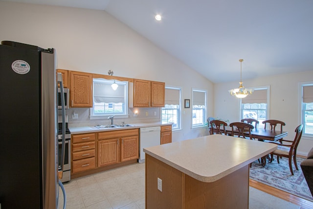 kitchen with a center island, sink, hanging light fixtures, stainless steel appliances, and backsplash