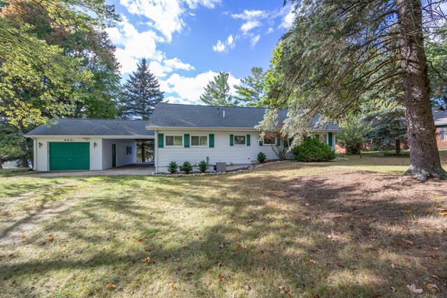 ranch-style house with a carport, a garage, and a front lawn