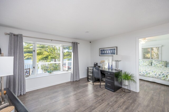 home office with dark hardwood / wood-style flooring and ceiling fan