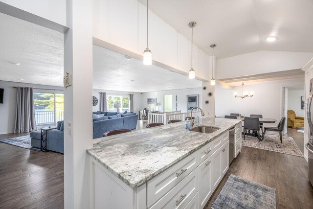 kitchen with pendant lighting, white cabinets, sink, dark hardwood / wood-style floors, and light stone countertops