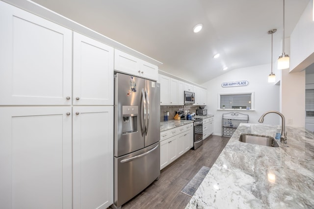 kitchen featuring white cabinetry, sink, stainless steel appliances, and decorative light fixtures