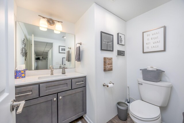 bathroom featuring vanity, hardwood / wood-style flooring, and toilet