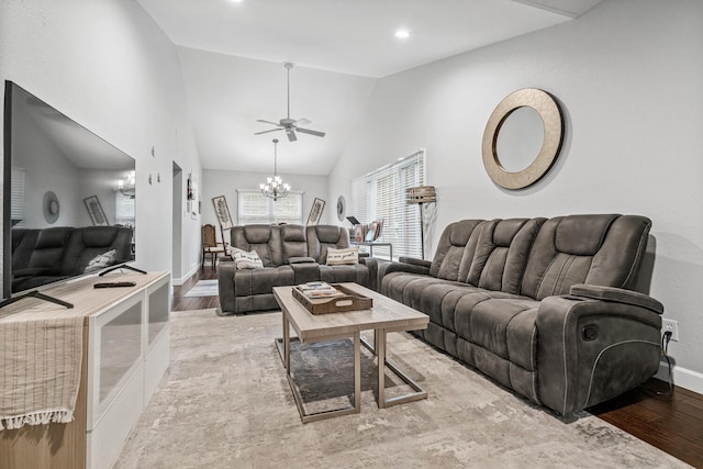 living room featuring ceiling fan with notable chandelier, high vaulted ceiling, and light hardwood / wood-style flooring