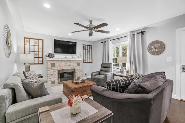 living room featuring a fireplace, wood-type flooring, and ceiling fan