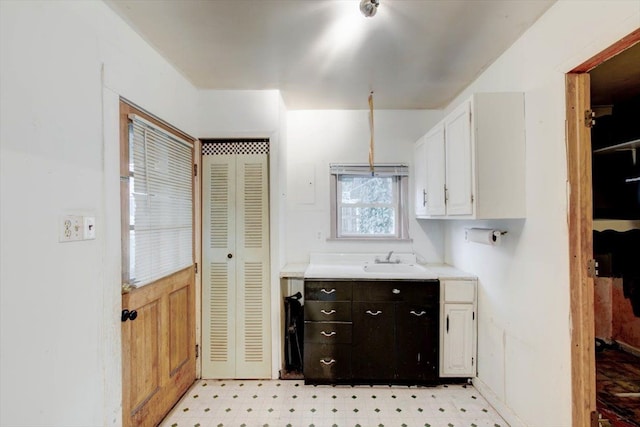 kitchen featuring dark brown cabinetry, sink, and white cabinets