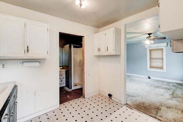 kitchen featuring white cabinets, light carpet, and ceiling fan