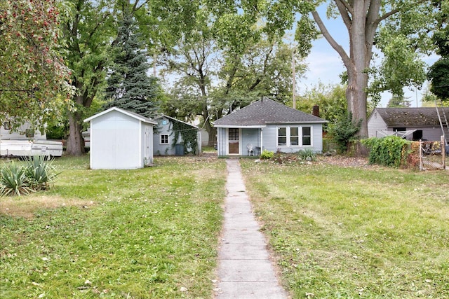 view of front of house featuring a front lawn and a storage unit