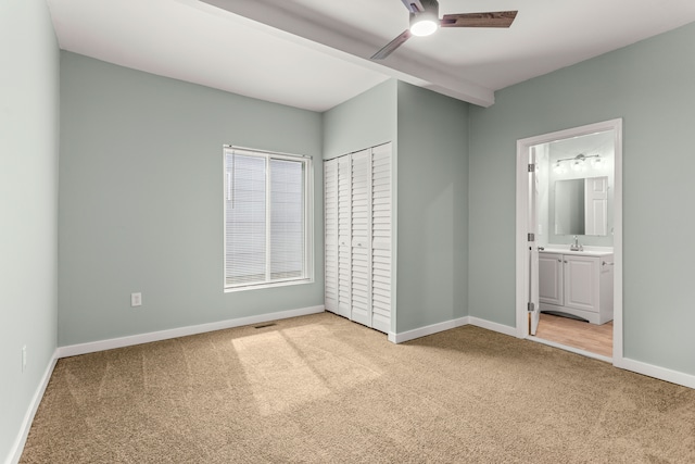 unfurnished bedroom with light carpet, ensuite bath, and ceiling fan