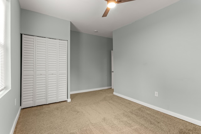 unfurnished bedroom with carpet, ceiling fan, and a closet