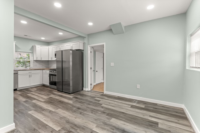 kitchen featuring white cabinetry, plenty of natural light, light hardwood / wood-style floors, and appliances with stainless steel finishes