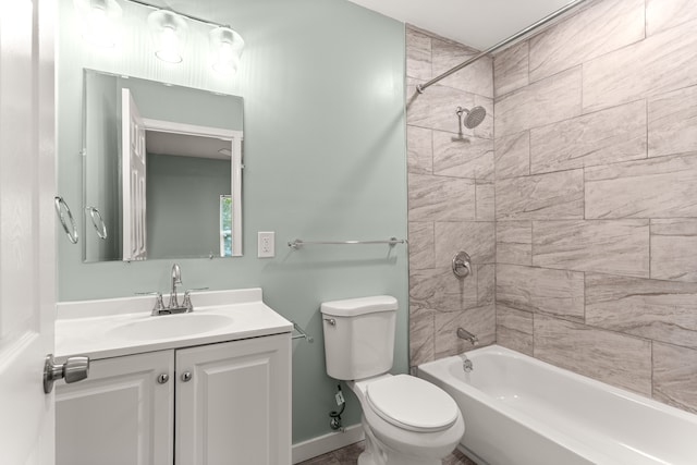 full bathroom featuring vanity, tiled shower / bath combo, and toilet