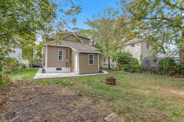 rear view of property featuring a patio and a lawn