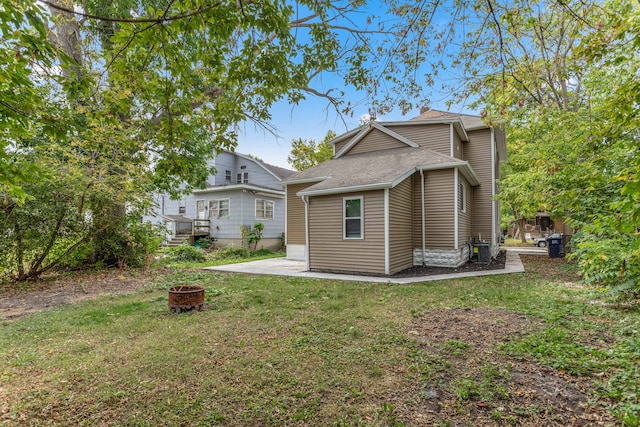 back of house featuring a yard and a fire pit