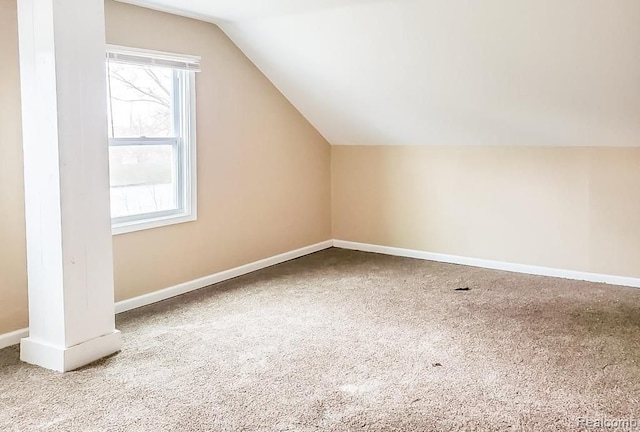 additional living space with carpet flooring and lofted ceiling