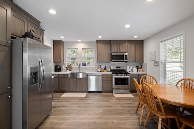 kitchen featuring a healthy amount of sunlight, sink, stainless steel appliances, and light hardwood / wood-style flooring