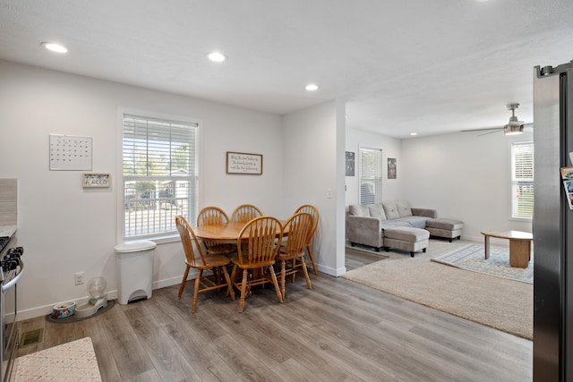 dining space with light wood-type flooring and ceiling fan