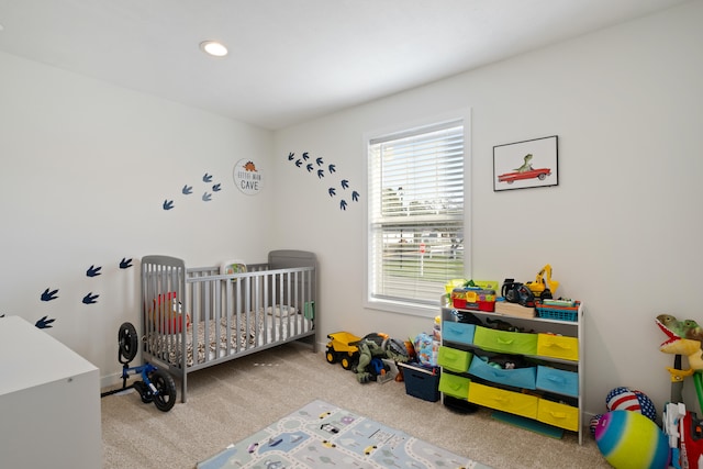 bedroom featuring carpet flooring and a nursery area