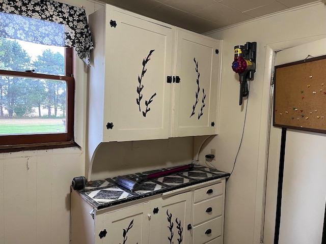 kitchen with white cabinetry and dark stone counters