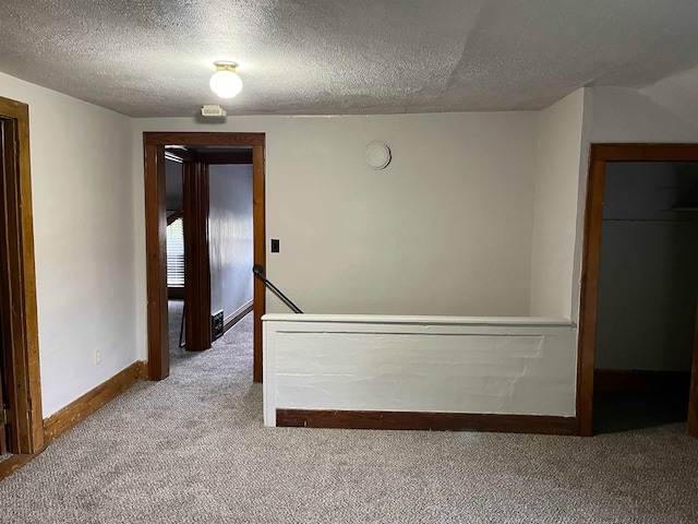 spare room with carpet flooring and a textured ceiling