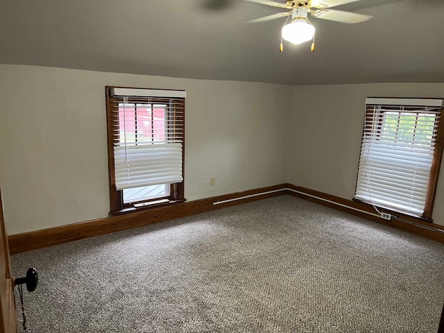 empty room featuring a wealth of natural light, carpet floors, and ceiling fan