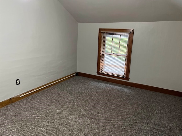 empty room featuring carpet and vaulted ceiling