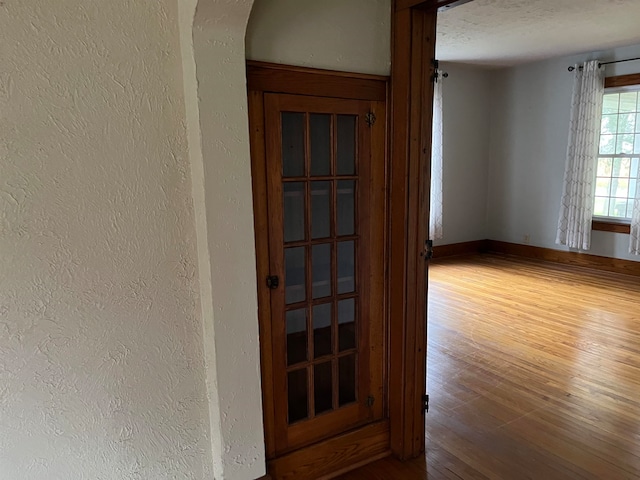 interior space with a textured ceiling and hardwood / wood-style flooring