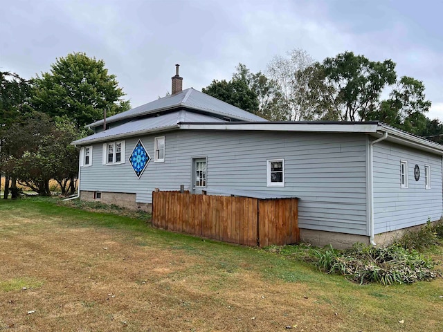 rear view of property featuring a lawn