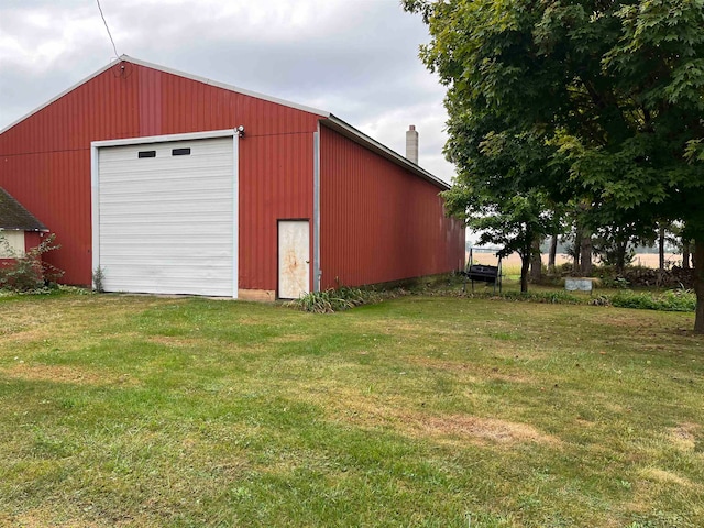 view of outdoor structure with a garage and a lawn