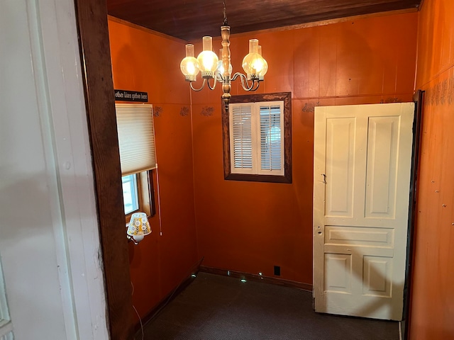 empty room with wooden walls and a chandelier