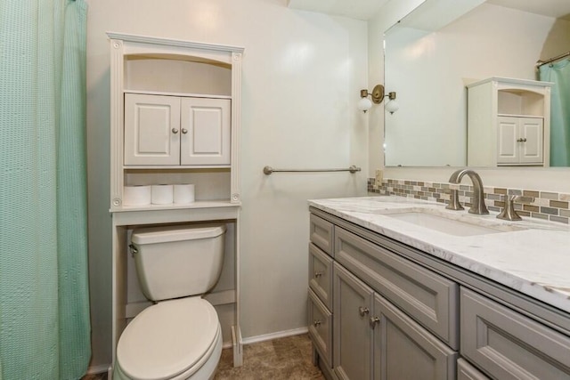 bathroom with vanity, toilet, and tasteful backsplash