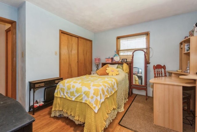 bedroom with light wood-type flooring and a closet