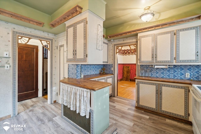 kitchen with butcher block counters, white range oven, light wood-type flooring, and crown molding