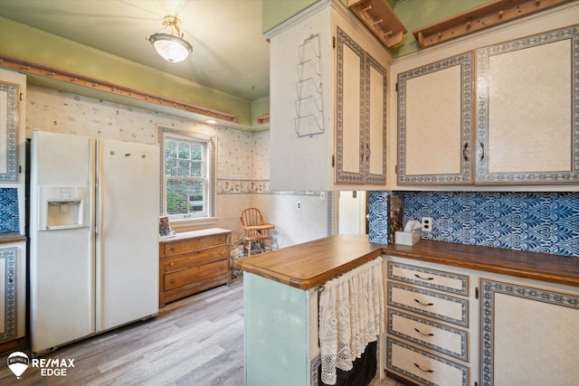 kitchen with kitchen peninsula, wooden counters, light hardwood / wood-style floors, and white refrigerator with ice dispenser