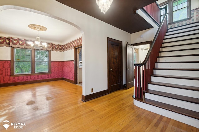 entryway featuring wood-type flooring and a notable chandelier