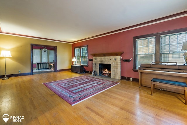 living room featuring hardwood / wood-style flooring, a wealth of natural light, and crown molding