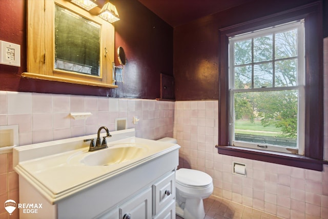 bathroom with tile patterned flooring, vanity, tile walls, and toilet