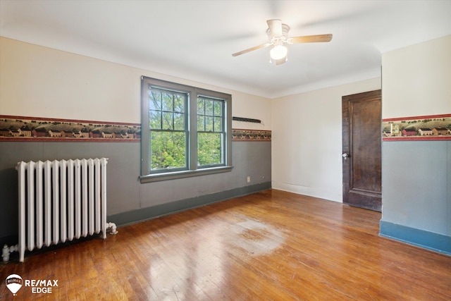 empty room with radiator, ceiling fan, and hardwood / wood-style floors