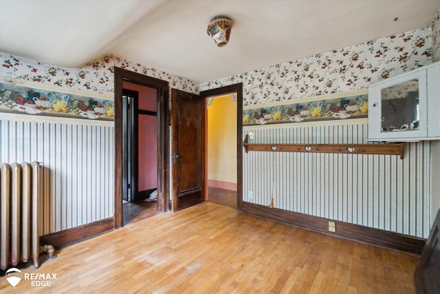 unfurnished room with wood-type flooring and radiator