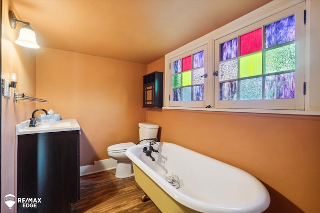 bathroom with wood-type flooring, a bathtub, a healthy amount of sunlight, and sink