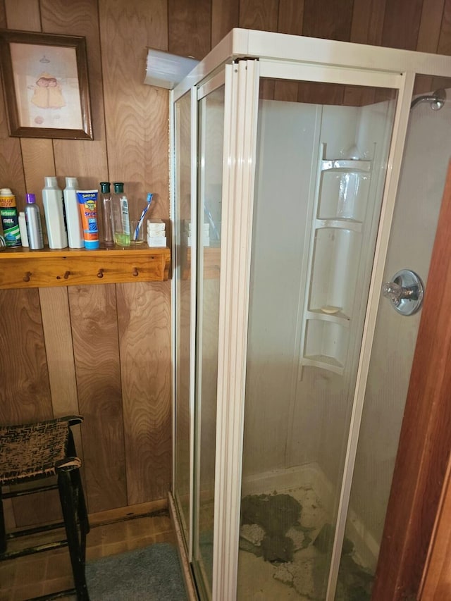 bathroom featuring wood walls and walk in shower