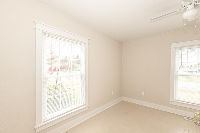 spare room featuring ceiling fan and a healthy amount of sunlight