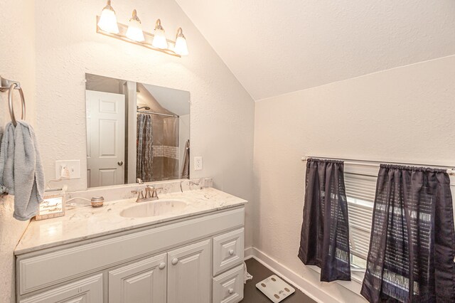 bathroom featuring a shower with curtain, vanity, and vaulted ceiling