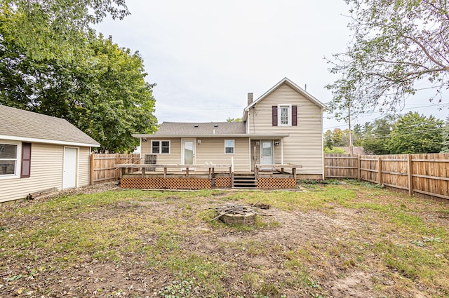 rear view of property with a deck and an outdoor fire pit