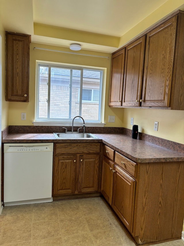 kitchen with dishwasher, light tile patterned floors, and sink