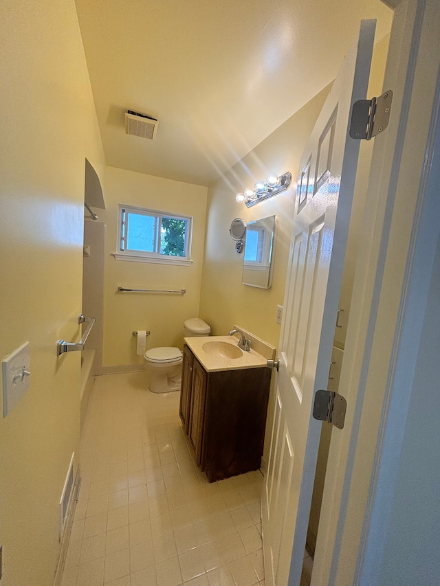 bathroom with tile patterned flooring, vanity, toilet, and walk in shower