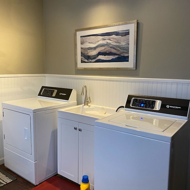 laundry room featuring washer and clothes dryer, dark hardwood / wood-style floors, cabinets, and sink