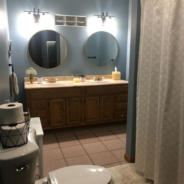 bathroom with tile patterned flooring, vanity, and toilet