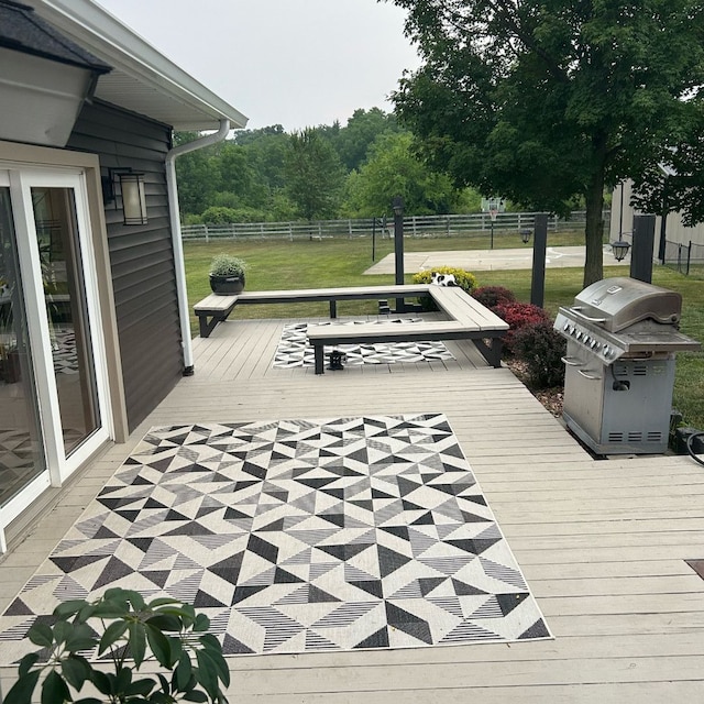 wooden terrace with a lawn and grilling area